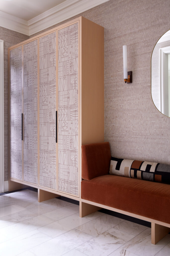 Built-in mudroom bench with integrated storage and wall-mounted mirror by Gillian Gillies Interiors