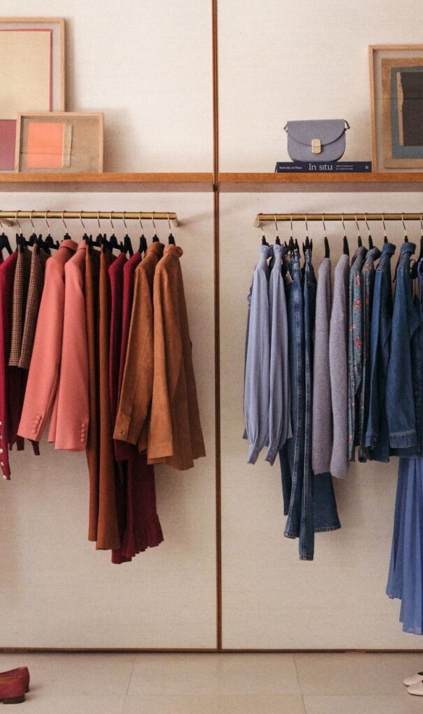 Colour-coordinated garments displayed on brass rails inside a Sézane boutique